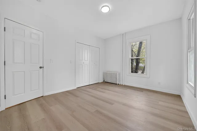 an empty room with windows and closet