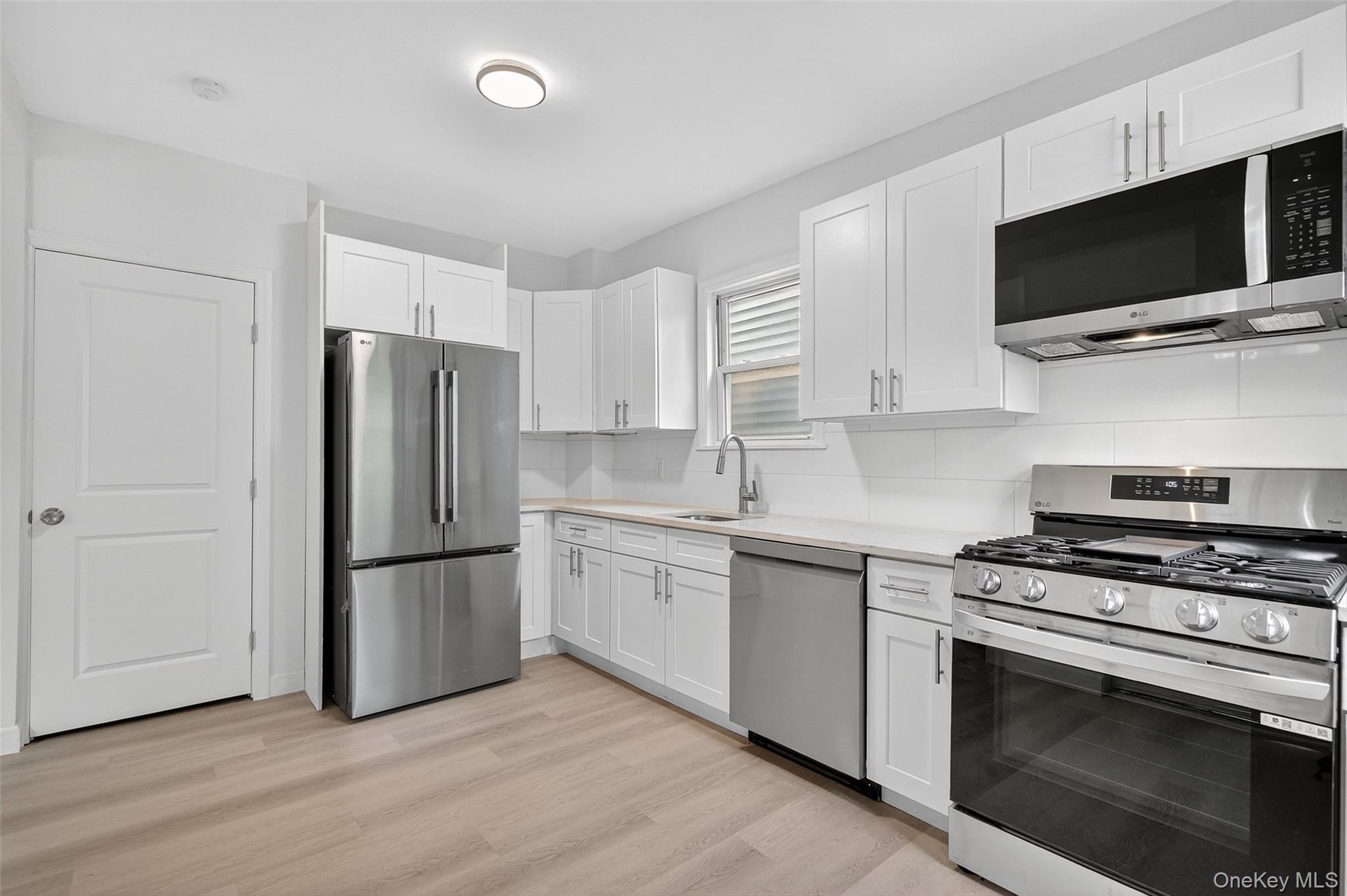 23 Ann Street, Unit 1 Ossining, NY 10562 - Photo 23 of 30 a kitchen with cabinets stainless steel appliances and wooden floor