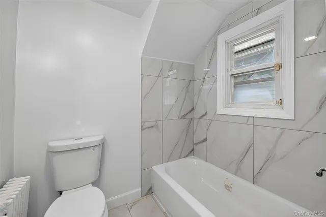 a bathroom with a toilet and bathtub