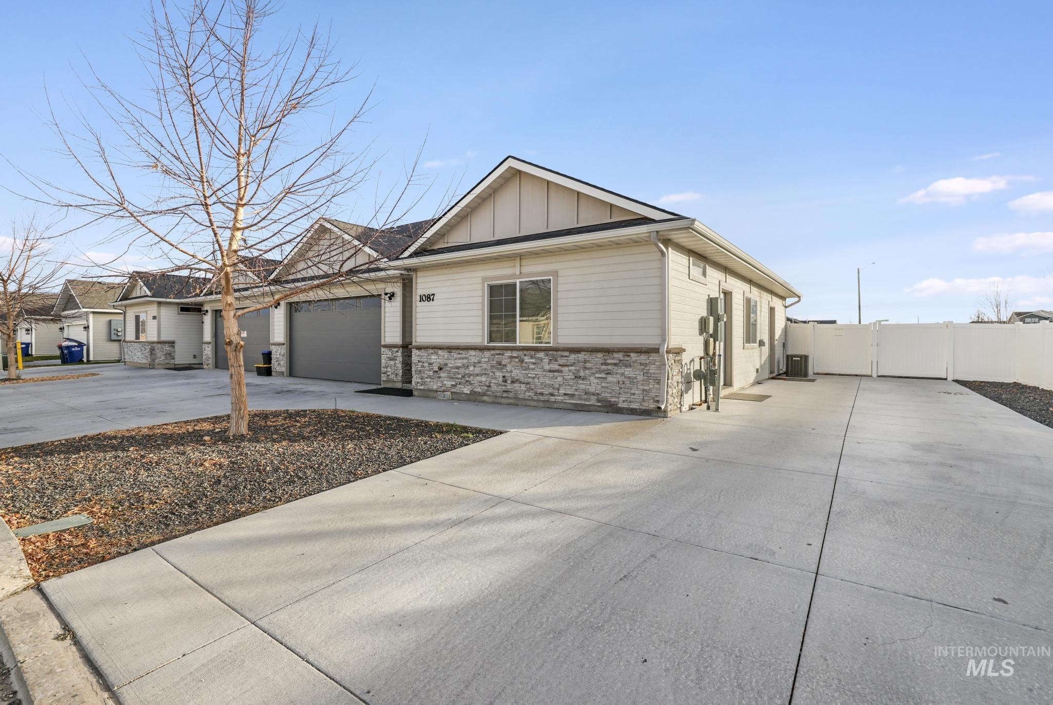 1087 Easy Avenue Twin Falls, ID 83301 - Photo 2 of 25 View of front of house featuring driveway, board and batten siding, stone siding, and a garage