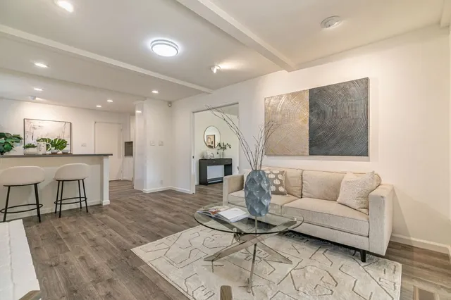a living room with furniture and a dining table with kitchen view