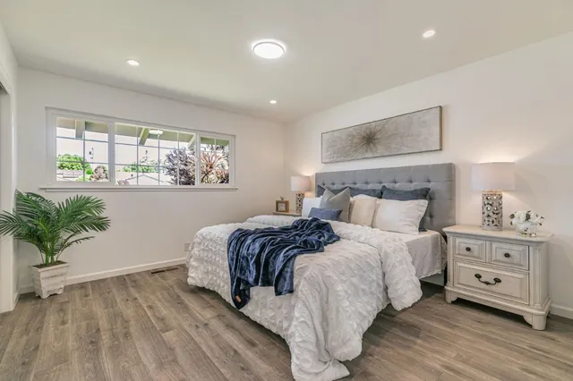 a bedroom with a large bed and a potted plant