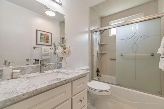 a bathroom with a granite countertop sink toilet and shower