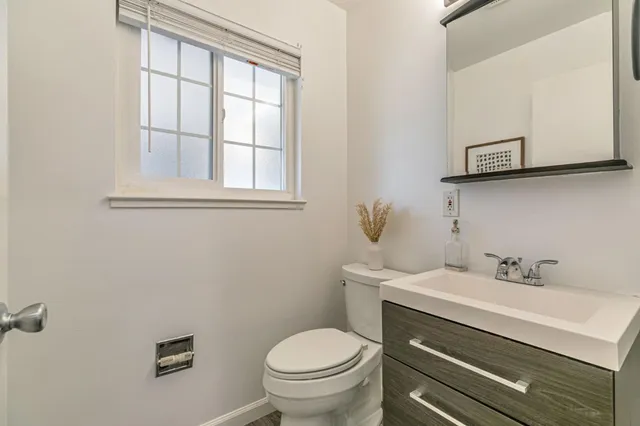 a bathroom with a toilet sink and mirror