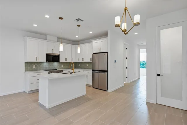 a kitchen with white cabinets and sink
