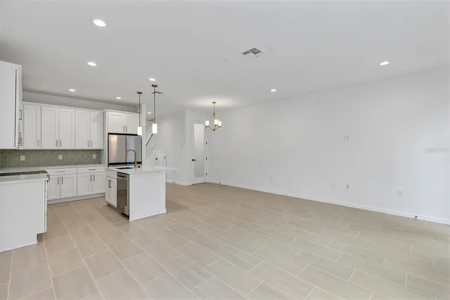 a kitchen with white cabinets and sink