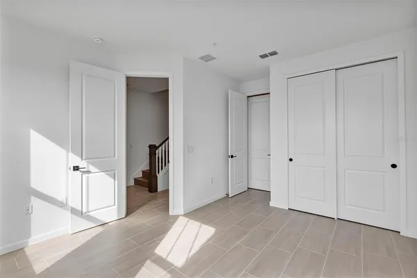 a view of kitchen with kitchen island sink refrigerator and white cabinets