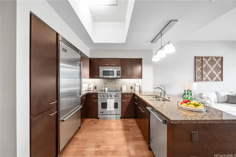 a kitchen with stainless steel appliances granite countertop a sink stove and refrigerator