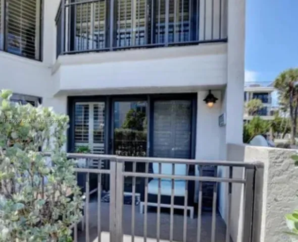 a view of a patio with couches potted plants and wooden floor