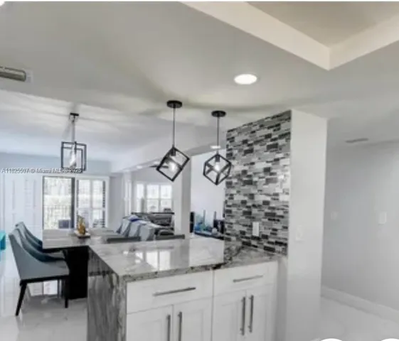 a kitchen with granite countertop a sink and a white stainless steel appliances