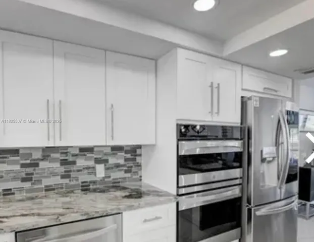 a kitchen with stainless steel appliances granite countertop a sink and a stove
