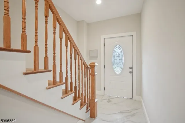 a view of staircase with railing and white walls