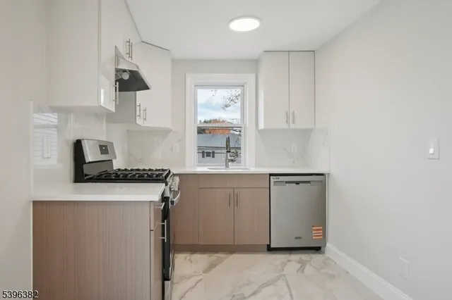 a kitchen with granite countertop white cabinets and white appliances