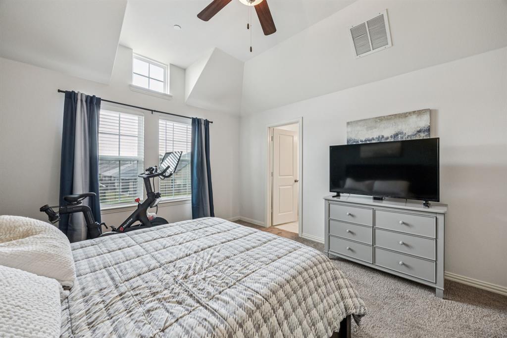 1010 Switchgrass Lane Allen, TX 75013 - Photo 16 of 25 a bedroom with a bed and a flat tv screen on dresser