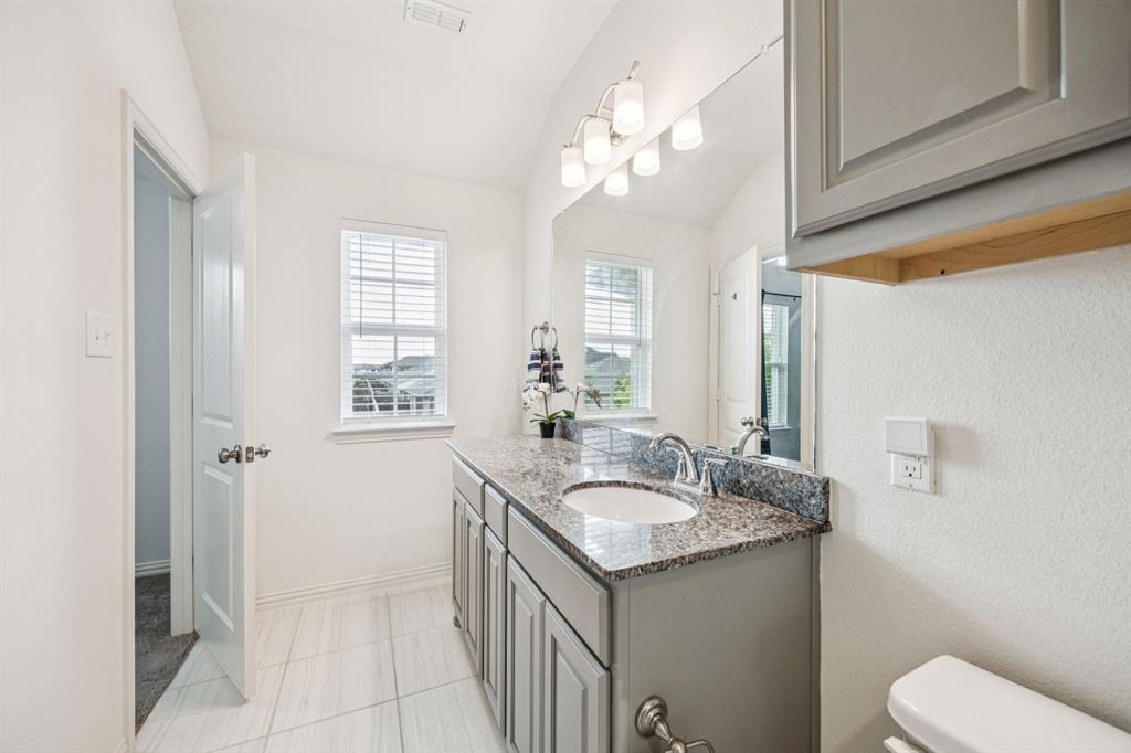 1010 Switchgrass Lane Allen, TX 75013 - Photo 18 of 25 a bathroom with a sink a toilet and a mirror