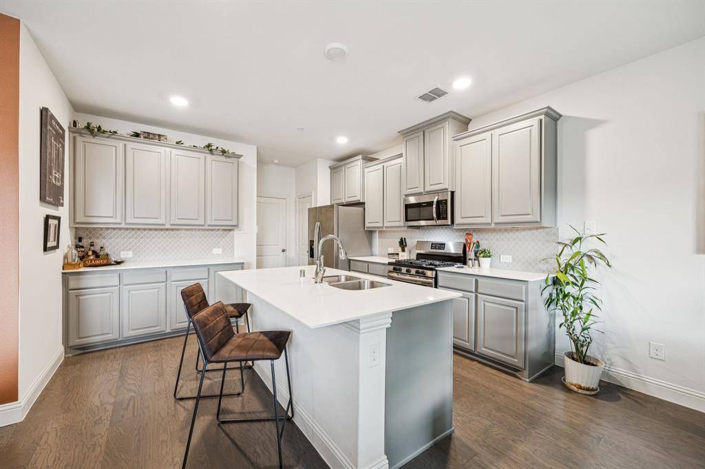 1010 Switchgrass Lane Allen, TX 75013 - Photo 2 of 25 a kitchen with white cabinets and stainless steel appliances