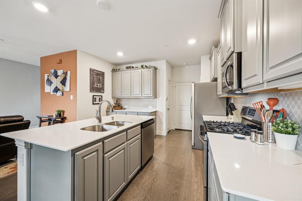 1010 Switchgrass Lane Allen, TX 75013 - Photo 8 of 25 a kitchen with a sink a refrigerator and cabinets