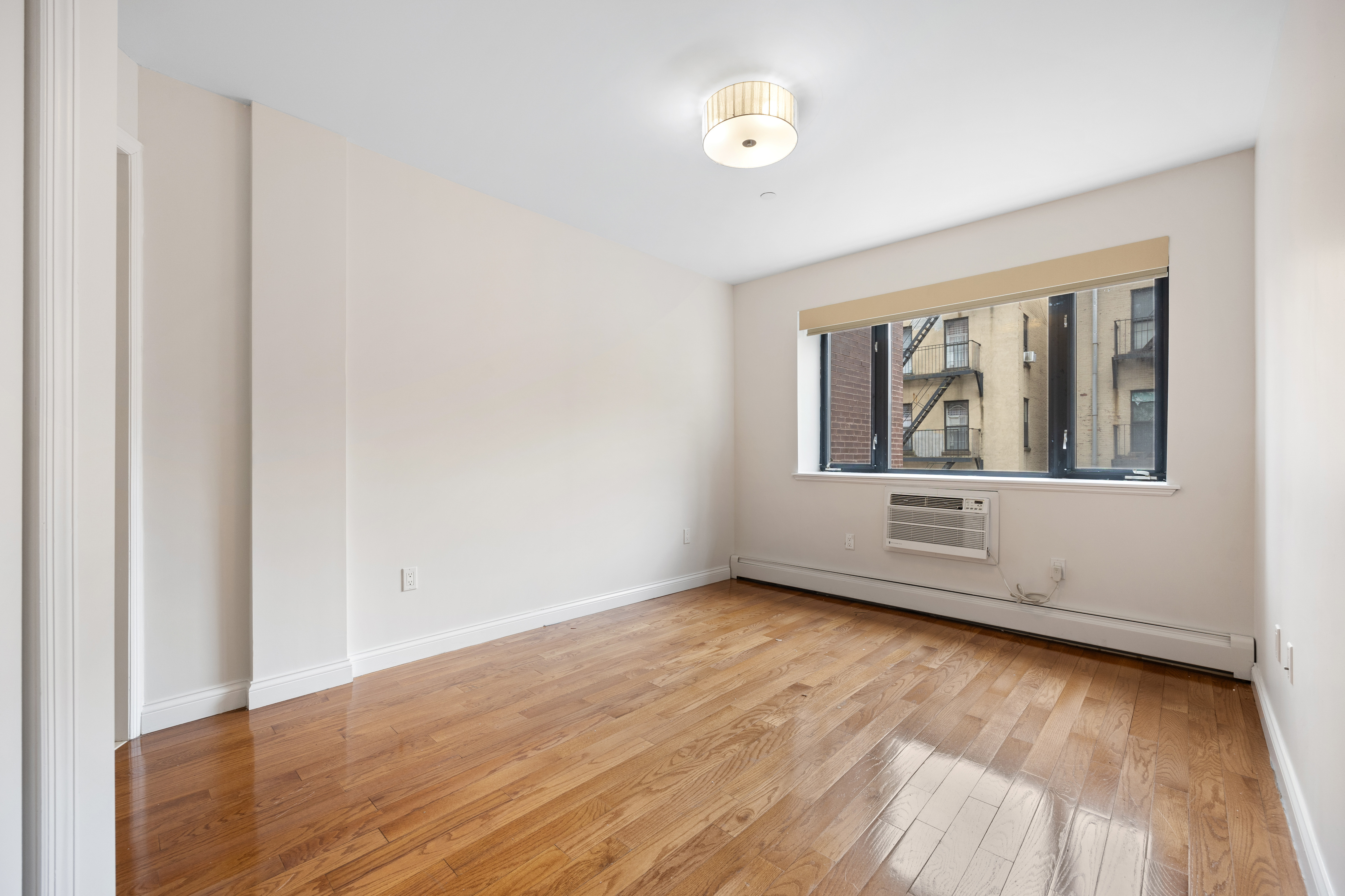 Undisclosed Address Manhattan, NY 10032 - Photo 9 of 19 an empty room with wooden floor and windows