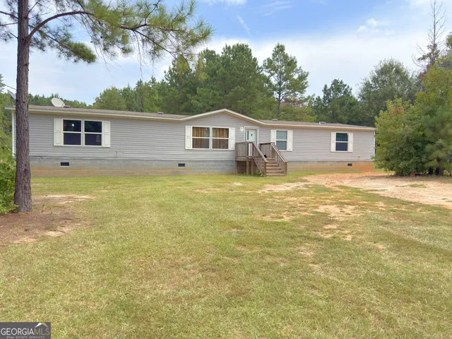 a view of a house with pool and a yard with trees in front of it
