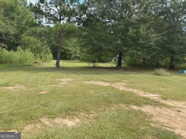 a view of a yard with large trees