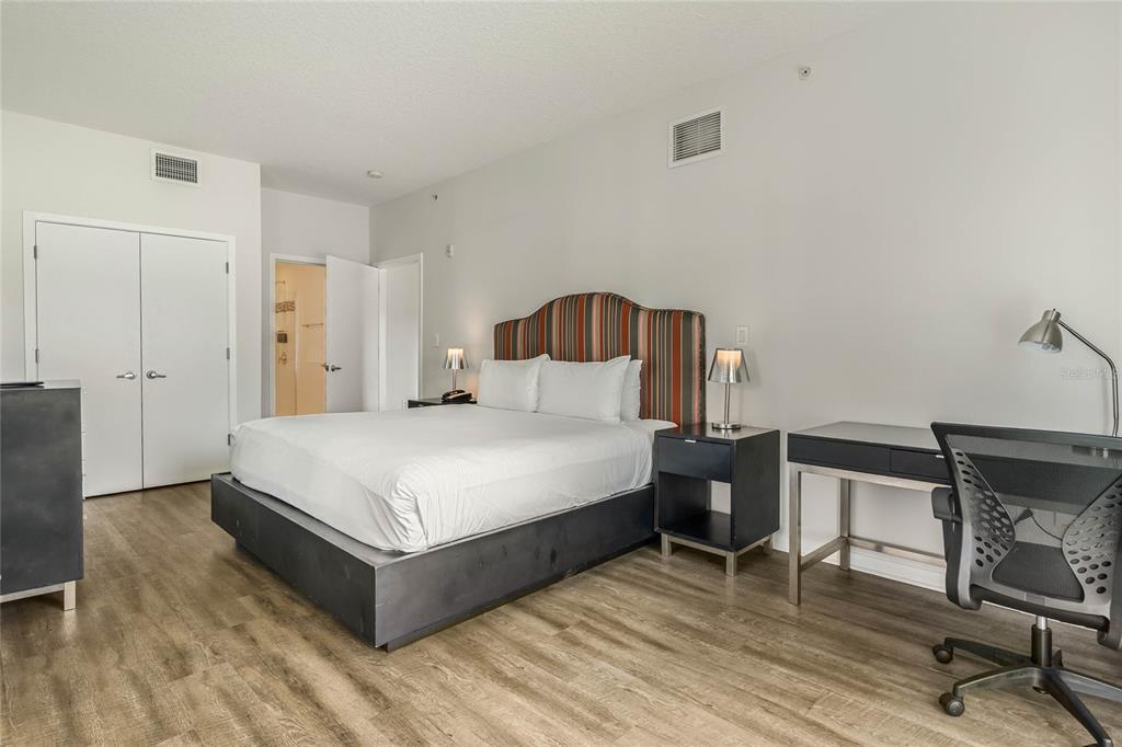 225 Celebration Place, Unit 117 Celebration, FL 34747 - Photo 10 of 30 a bedroom with a bed and a chair