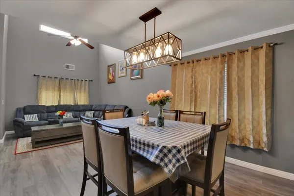 a dining room with furniture a chandelier and wooden floor