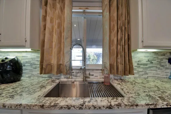 a view of a kitchen with a sink and wooden floor