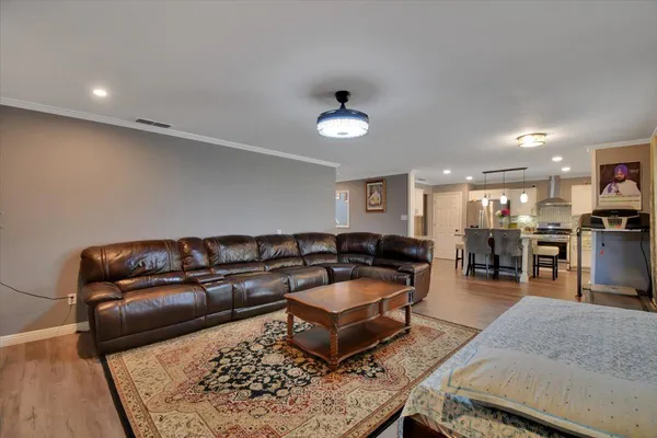 a living room with furniture a wooden floor and chandelier