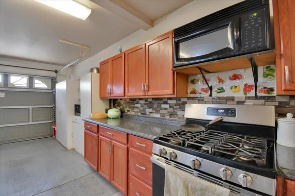 a kitchen with stainless steel appliances granite countertop a stove and a microwave