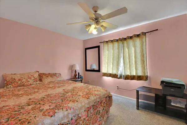a bedroom with a bed window and a chandelier