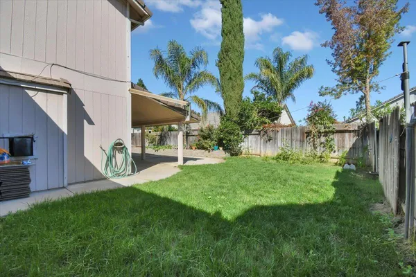 a view of a chair and table in backyard of the house