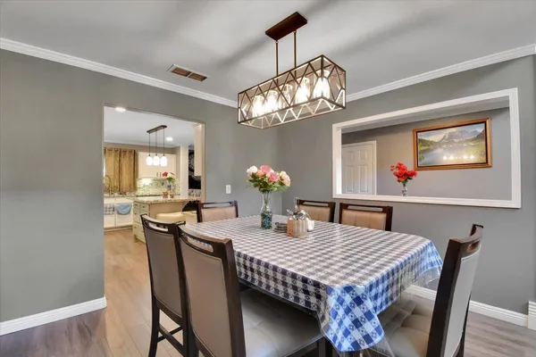 a dining room with furniture a chandelier and wooden floor
