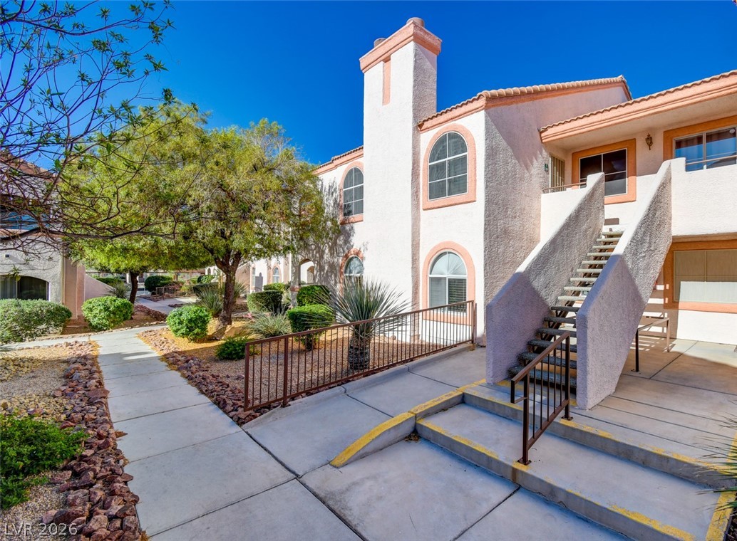 A desert-friendly landscape surrounds this multi-story building, offering direct outdoor access for residences.