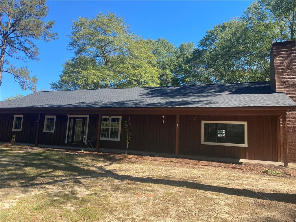 25 Gas Line Road Phenix City, AL 36870 - Photo 2 of 52 View of front of home with a shingled roof, a porch, a chimney, and a front yard
