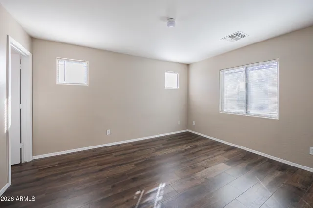 a view of an empty room with wooden floor