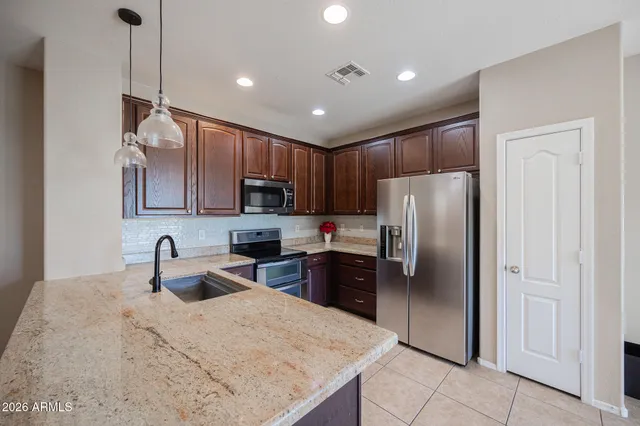 a kitchen with stainless steel appliances granite countertop a refrigerator a sink a stove a microwave and island