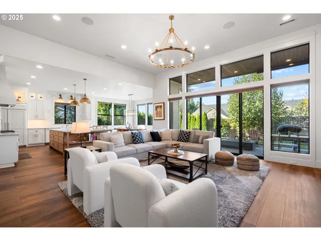a view of living room kitchen with stainless steel appliances granite countertop stove and wooden floor