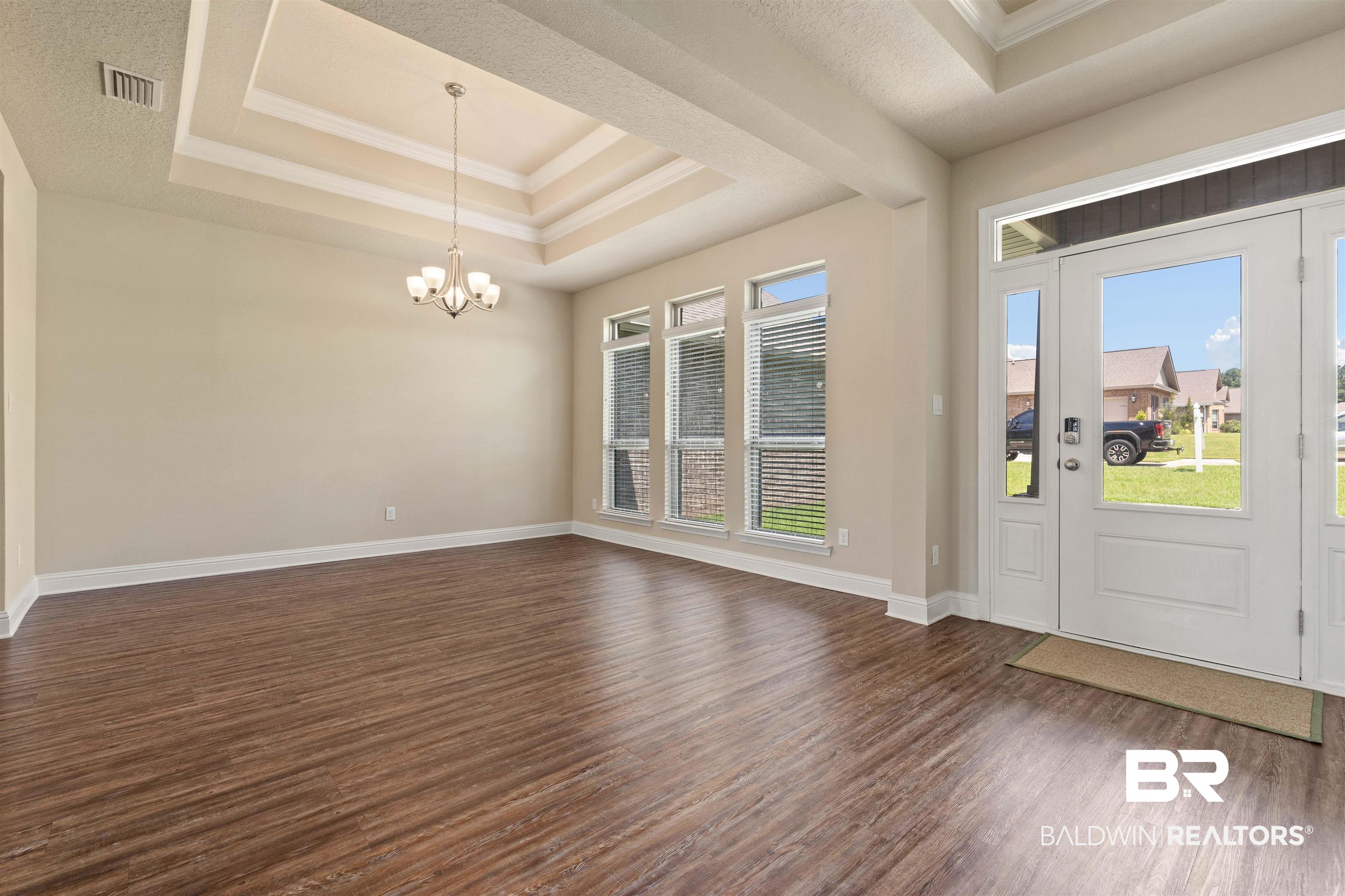 1864 Gwin Court Mobile, AL 36695 - Photo 15 of 37 Entrance foyer featuring a tray ceiling, dark wood-type flooring, a chandelier, and a wealth of natural light