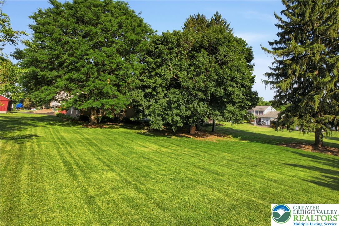 4682 Steuben Road Bethlehem, PA 18020 - Photo 58 of 79 A verdant, well-maintained lawn stretches toward distant residential structures, framed by mature trees.
