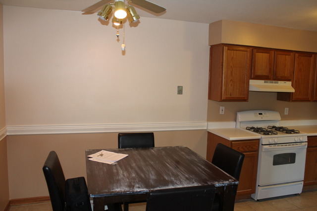 19330 Wolf Road, Unit 12 Mokena, IL 60448 - Photo 5 of 6 a kitchen with a table chairs and a stove