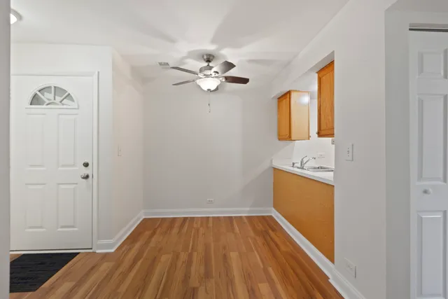 a view of a kitchen with wooden floor and a ceiling fan