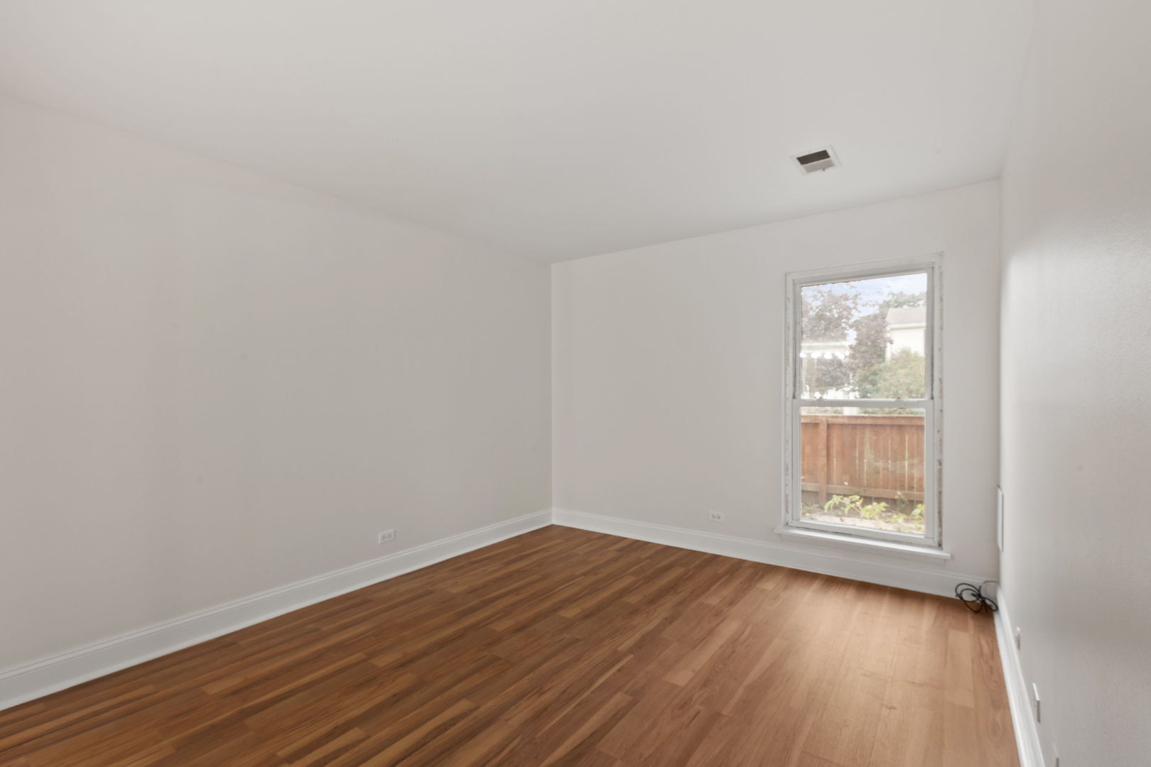 1975 Kenilworth Circle, Unit B Hoffman Estates, IL 60169 - Photo 17 of 21 a view of an empty room with wooden floor and a window