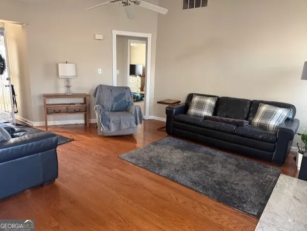 a living room with furniture and a wooden floor