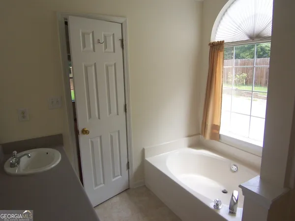 a bathroom with a tub a sink and a shower