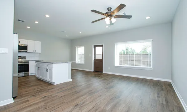 a kitchen with stainless steel appliances granite countertop a refrigerator sink and white cabinets