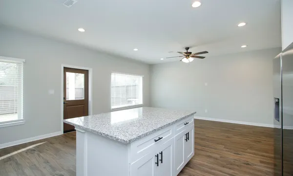 an empty room with a window and a fan