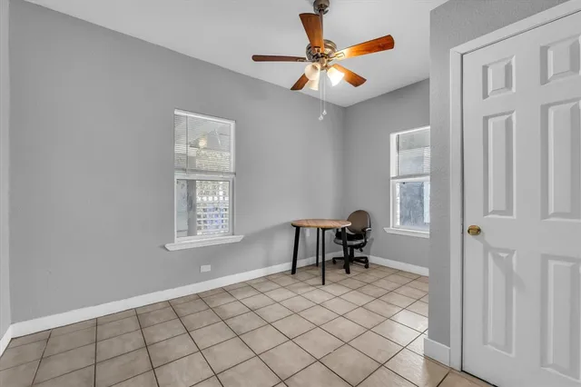 a view of a room with a chandelier fan and a window