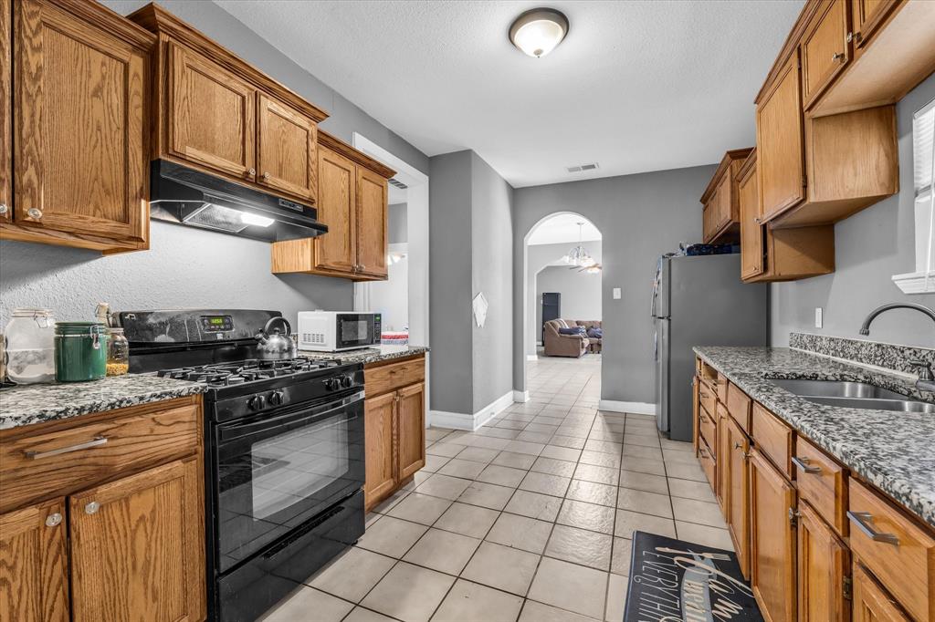 1822 Herring Avenue Waco, TX 76708 - Photo 7 of 26 a kitchen with stainless steel appliances granite countertop a stove a sink and a microwave