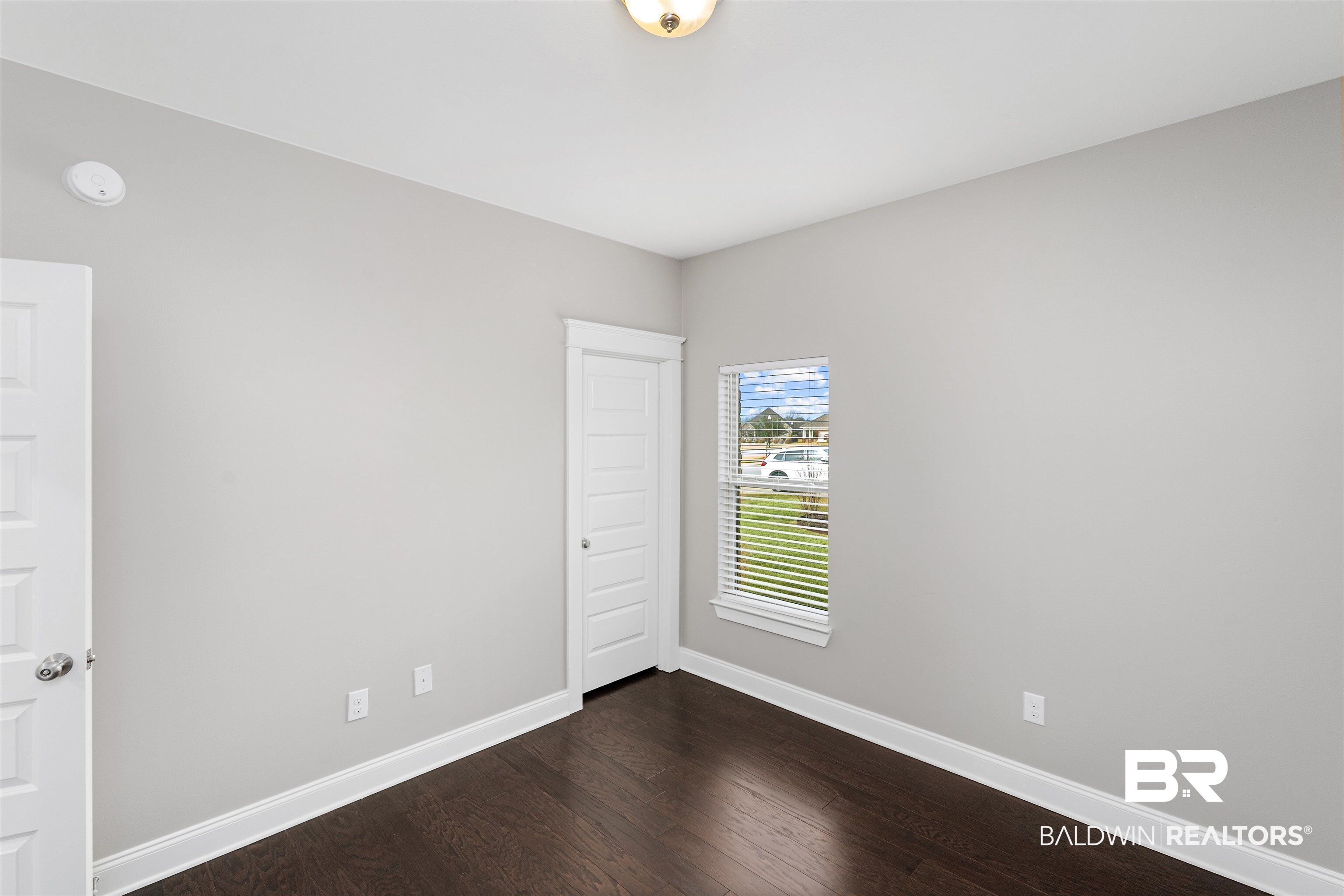 24838 Slater Mill Road Daphne, AL 36526 - Photo 23 of 46 Empty room with dark wood-type flooring and baseboards