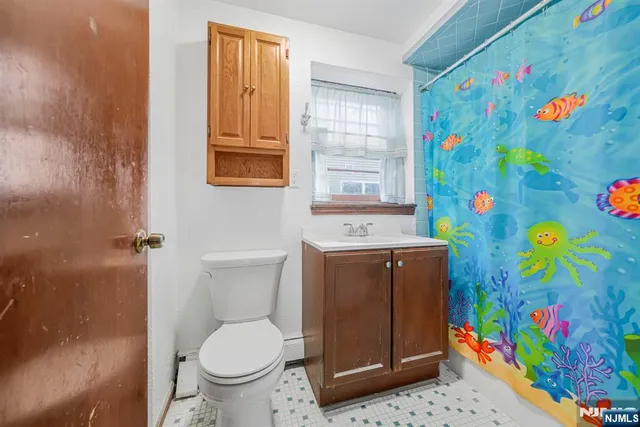 a bathroom with a toilet and a shower curtain